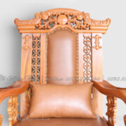 Trung tâm đỉnh ghế được xử lý bằng một mảng tròn nổi bật, tạo thành điểm neo cho toàn bộ bố cục. Từ tâm này, những họa tiết hoa lá cuốn phát triển sang hai bên. Cách tổ chức đối xứng giúp phần đỉnh dù có nhiều chi tiết nhưng không tạo cảm giác rời rạc.